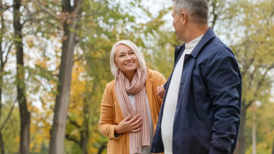 Dating sider for voksne singler: et par går en tur i en park om efteråret